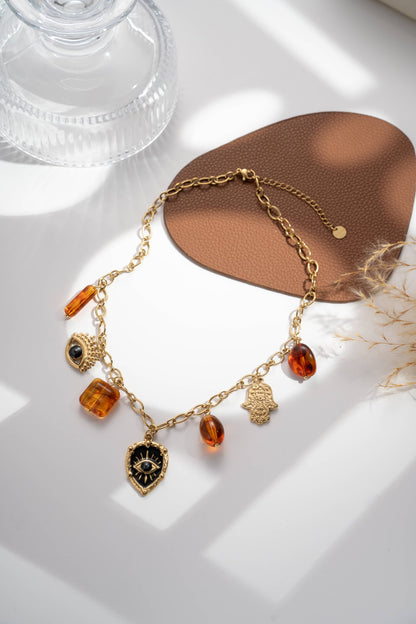 Collier protection œil noir ambre chaud main charme lumineux